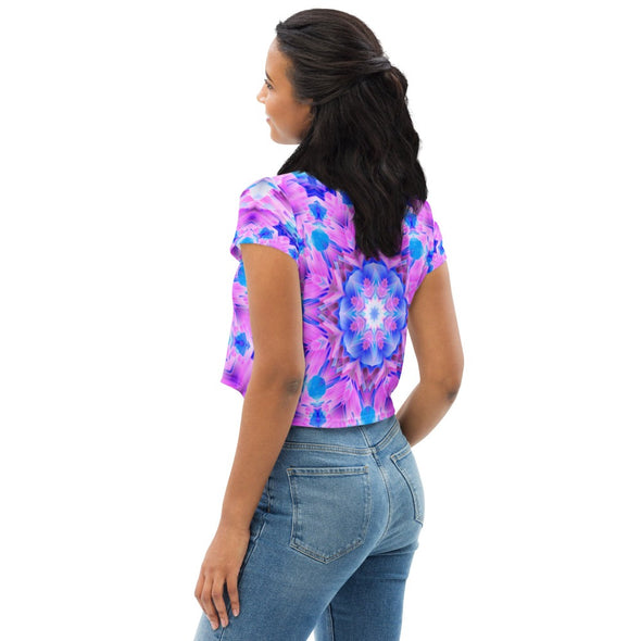 Photograph of a model wearing a unisex Bleace MetaParty Vibes Kaleidoscopic pink, light blue, Trippy Visual crop top shirt.  