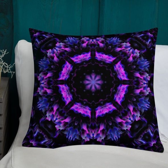 Photograph of a model wearing Bleace unisex MetaParty Vibes Kaleidoscopic purple, blue, and pink, Trippy Visual pillow placed on a chair in the foreground with a white couch in the background.  